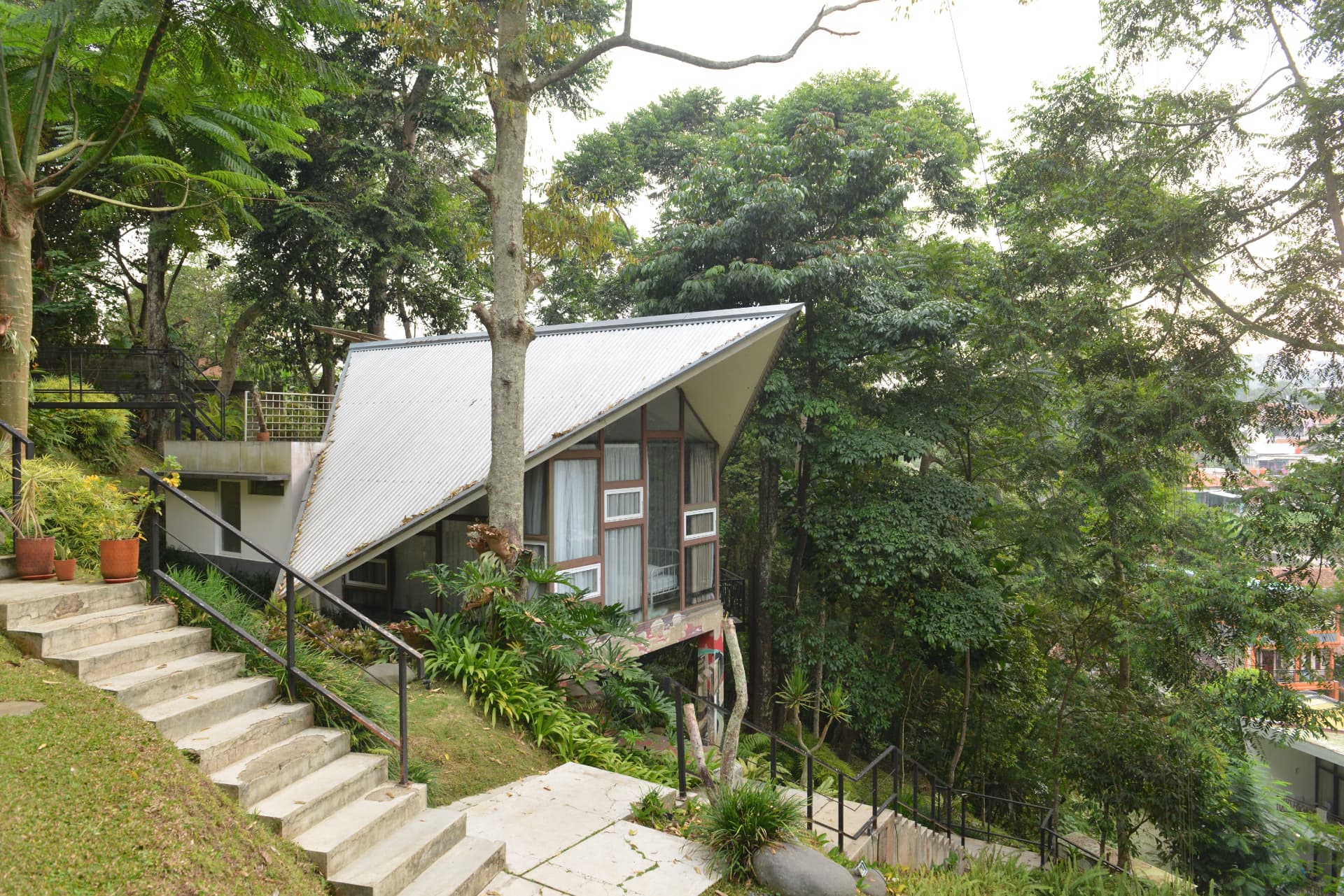 Hillside villa with steep roof and stone steps overlooking the valley